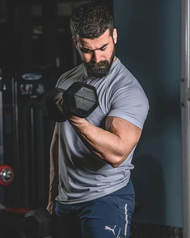 Hombre haciendo curl de bíceps con una mancuerna