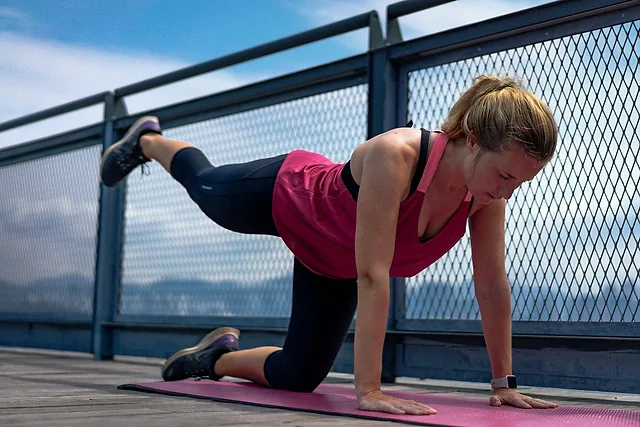 Mujer haciendo el ejercicio bird dog sobre una esterilla